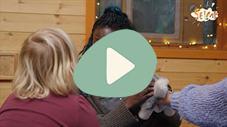 Voksen barnehageansatt som snakker til et barn